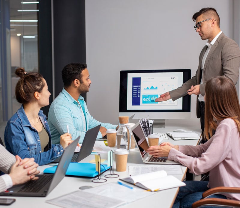 Business team in a meeting reviewing financial data on a screen, representing CFO services for marketing agencies and small businesses.