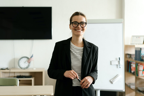 A woman explaining on the whiteboard about the process to use the right approach for building a revenue plan.